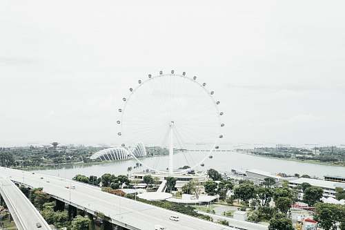 amusement park white ferris wheel beside body of water leisure activities